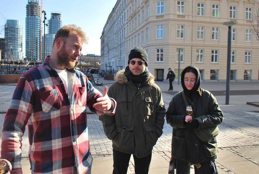 Copenhagen: Politically Incorrect Beer Tasting Walking Tour - Vesterbro with a beer glass in hand, and a plan in motion